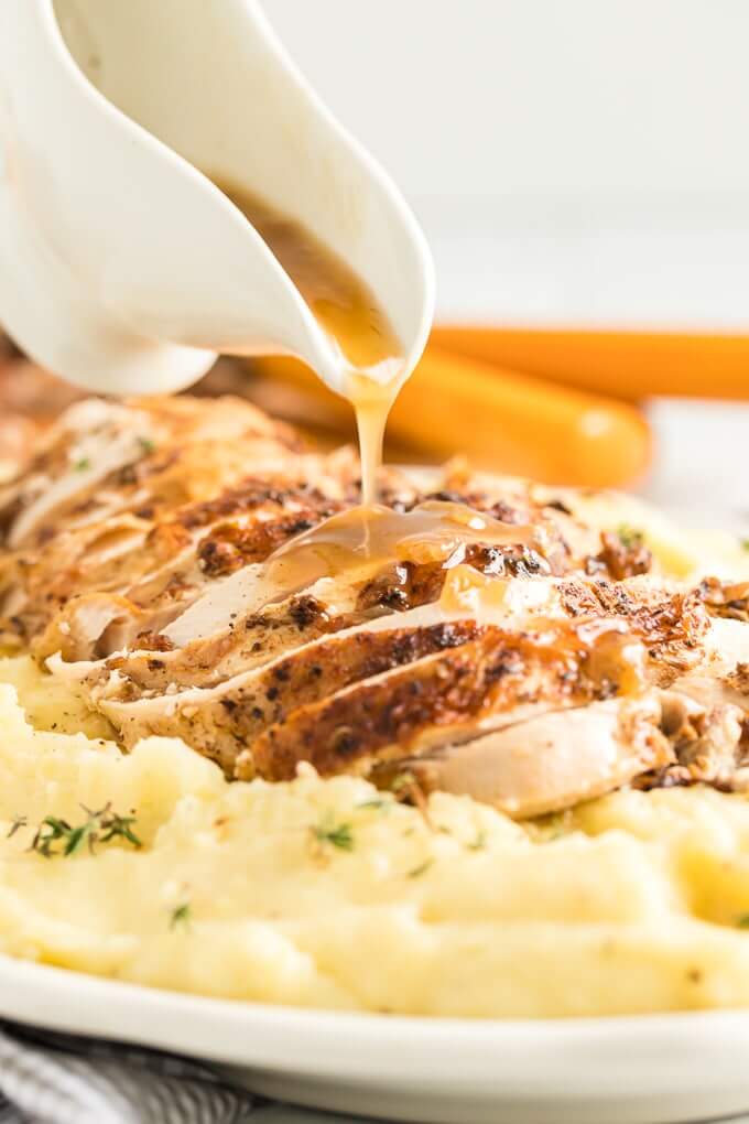 gravy poured over sliced turkey breast and mashed potatoes